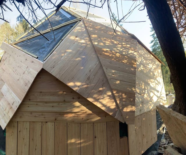Le dôme géodésique bardé de bois avec sa lucarne vitrée