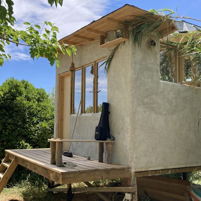 Le mini habitat sur pilotis vu de l'extérieur, terrasse en bois