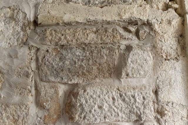Mur en granit aux joints refaits à la chaux, gros plan