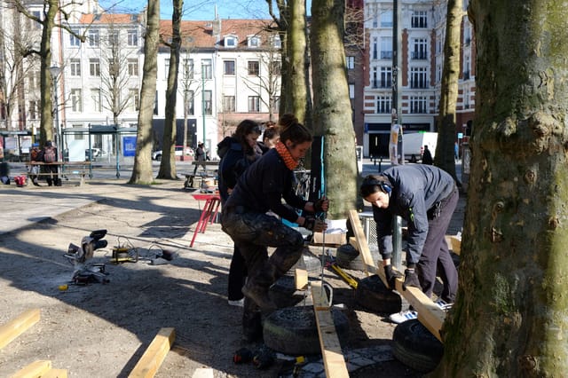 Participants assemblent le mobilier au pied des arbres du square