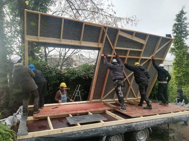 Participants relevant un mur en ossature bois sur la remorque de la tiny house