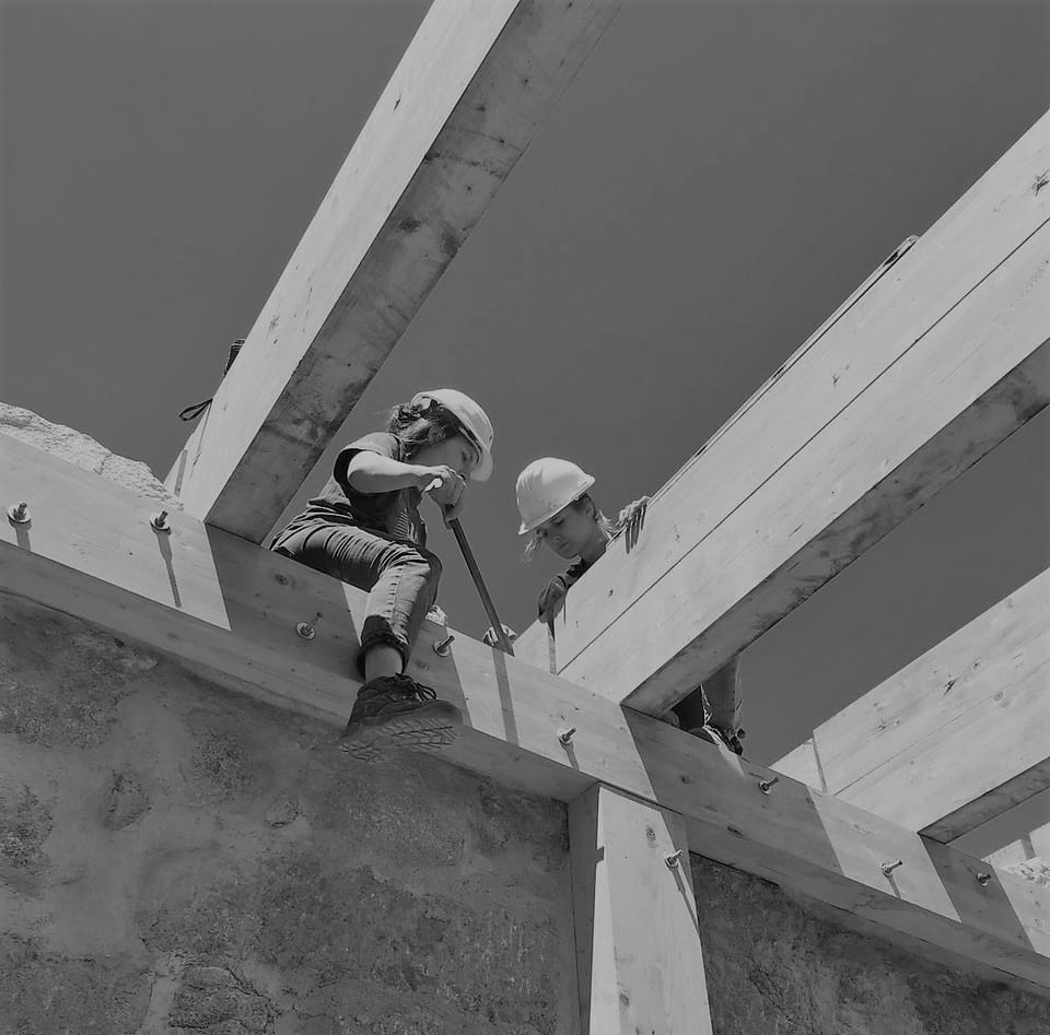 Laurane Coornaert sur un chantier d'autoconstruction, prête à échanger sur votre projet