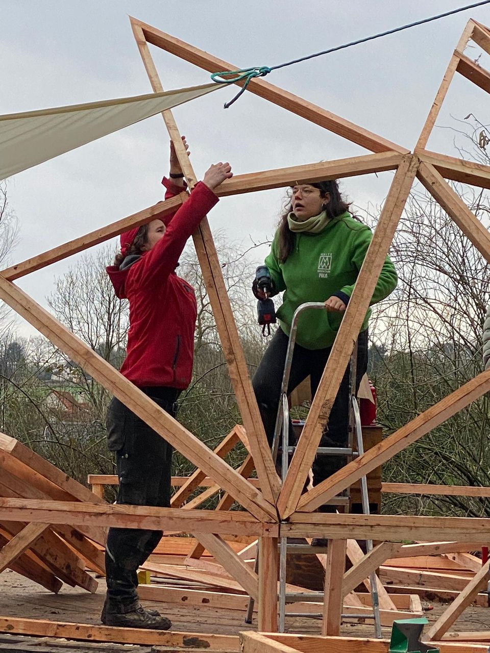 Participants assemblant les triangles de bois du dôme géodésique
